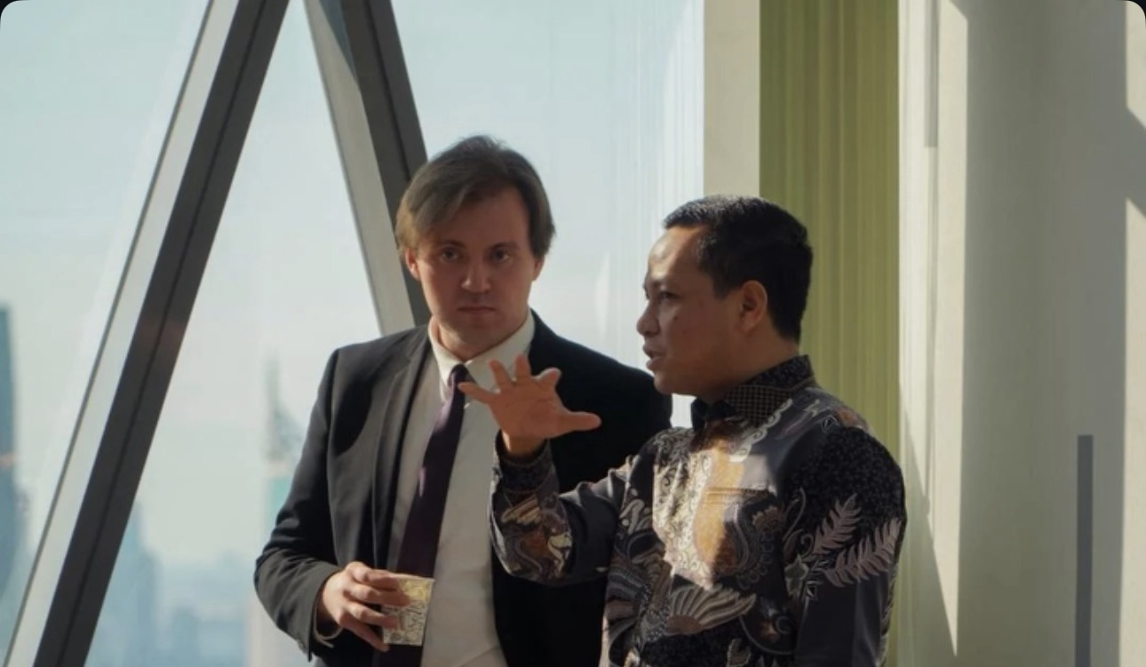 Two event guests having a conversation beside a sunlit window